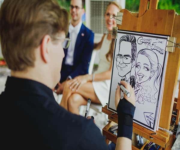 Caricaturist doing a sketch of a couple as they smile