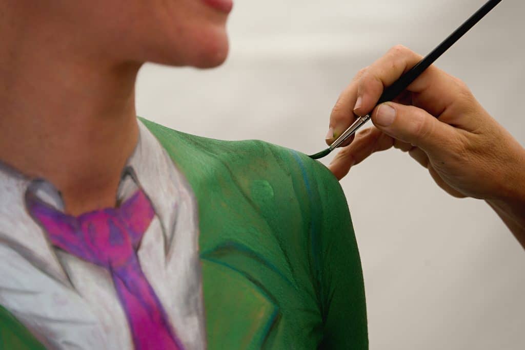 person having body painted to appear like a green suit