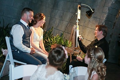 bride and groom being sketched by artist