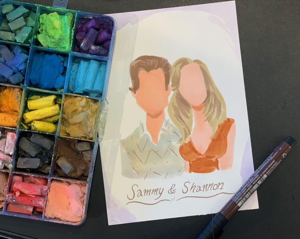 portrait of a couple next to multicolored chalk