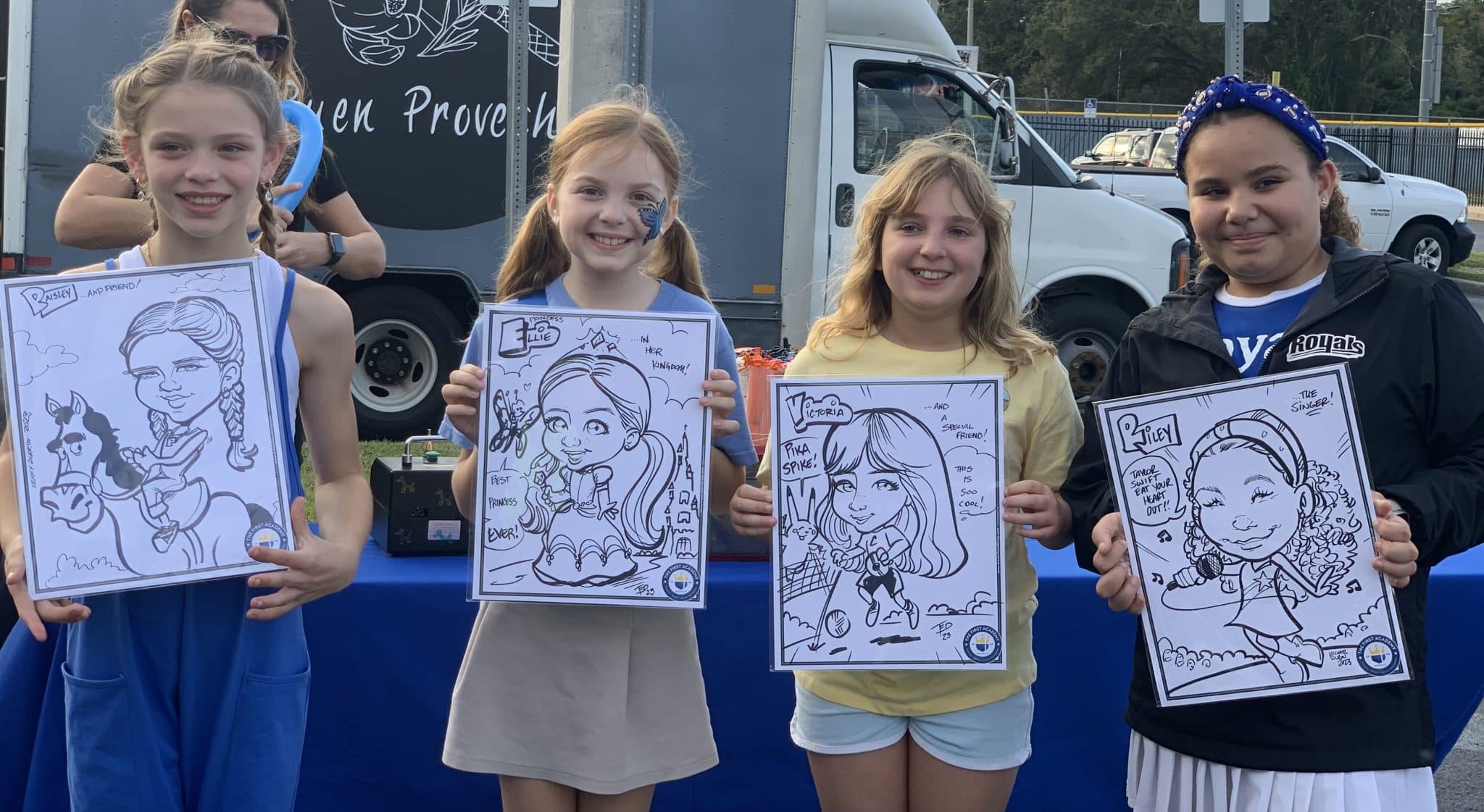 little girls holding up caricatures of themselves