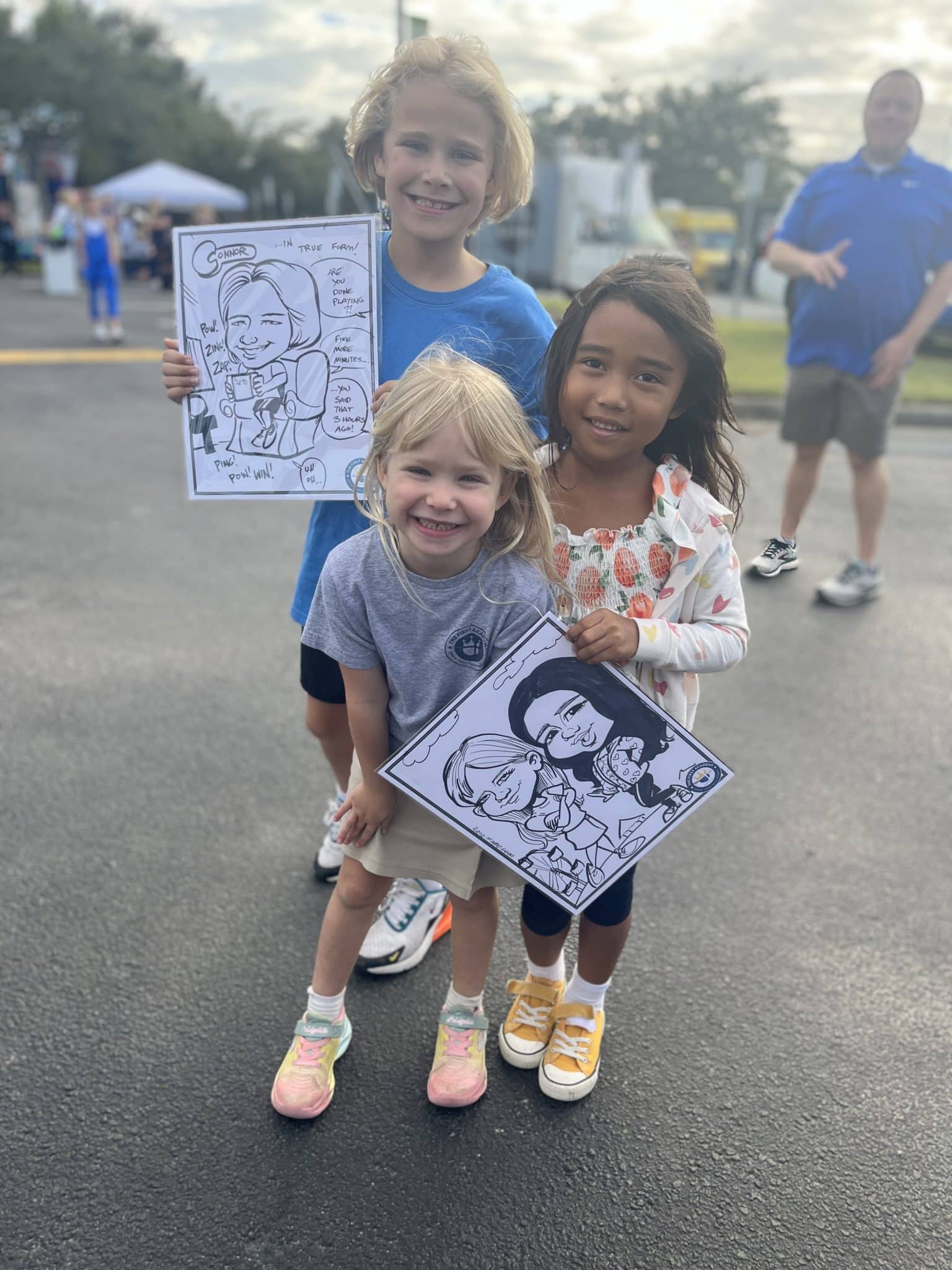 Kids holding up caricature drawings.