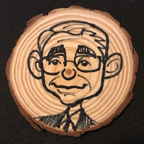 man's faced drawn on wooden coaster