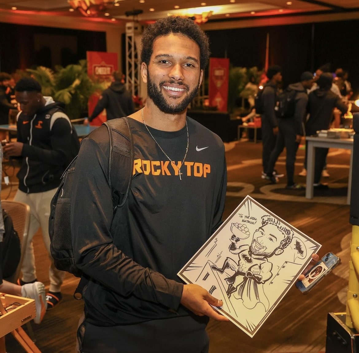 football player holding caricature of himelf