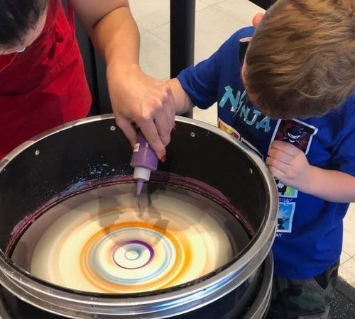 kids dropping paint in spin art